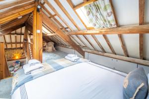 une chambre avec un lit dans un grenier dans l'établissement Bellas Barn by Big Skies Cottages, à Weybourne