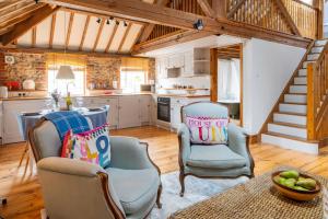 une cuisine avec deux chaises et une table dans l'établissement Bellas Barn by Big Skies Cottages, à Weybourne