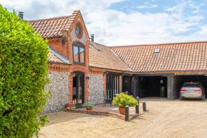 une maison avec une voiture garée dans l'allée dans l'établissement Bellas Barn by Big Skies Cottages, à Weybourne