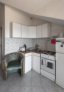 a kitchen with white cabinets and a stove top oven at The View Savina - Herceg Novi in Herceg-Novi +4 photos