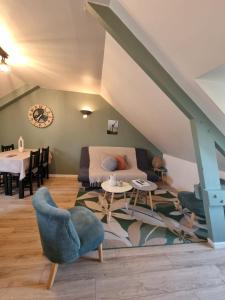 a living room with a blue chair and a couch at HAVRE MARIN DU CENTRE VILLE lumineux, spacieux à 5 min de la plage in Dinard