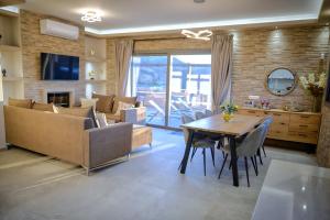 a living room with a couch and a table and chairs at Secluded Luxury Villa w Jacuzzi & Stunning Views in Kali Limenes