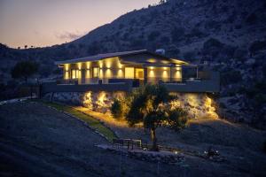 a house on a hill at night with lights at Secluded Luxury Villa w Jacuzzi & Stunning Views in Kali Limenes