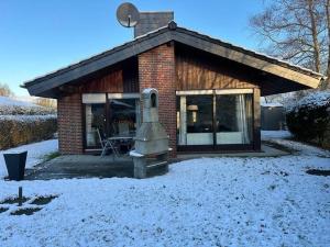 a small brick house with a statue in the snow at Schwalbennest in Tossenserdeich