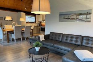 a living room with a leather couch and a table at Schwalbennest in Tossenserdeich