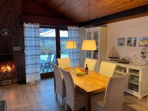 a dining room with a table and chairs and a fireplace at Schwalbennest in Tossenserdeich +7 photos