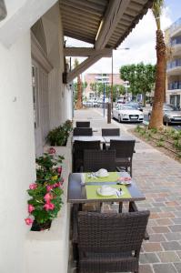 een patio met tafels, stoelen en bloemen bij Hotel Le Revest in Sainte-Maxime