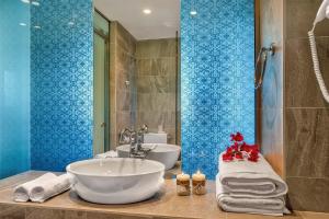 La salle de bains est pourvue d'un lavabo blanc et d'une douche. dans l'établissement Belvedere Andros, à Batsi