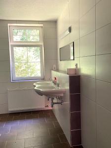 a bathroom with a sink and a window at Rennsteighostel in Ruhla +19 photos