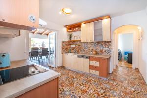 eine Küche mit Holzschränken und Fliesenboden in der Unterkunft Villa Andrea ZadarVillas in Zaton + 35 Fotos