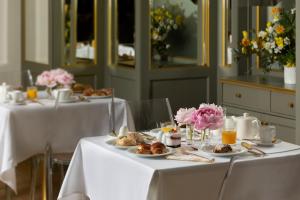 two tables with plates of food and flowers on them at Hotel Liberty in Prague