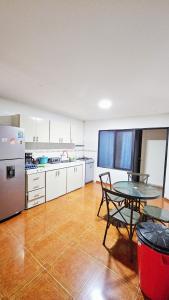 a kitchen with a table and a table and a refrigerator at Mom's house Colombia in Cali