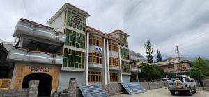 een gebouw met groene ramen en een auto voor de deur bij Adventure Sarai Skardu in Skardu