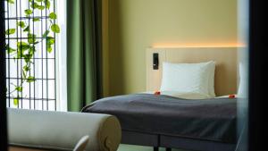 Un dormitorio con una cama y una ventana y un sofá. en Citybox Kristiansand, en Kristiansand