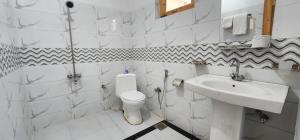 een witte badkamer met een wastafel en een toilet bij Adventure Sarai Skardu in Skardu +54 foto's