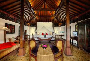a bedroom with a bed and a couch and a table at MesaStila Resort and Spa in Borobudur