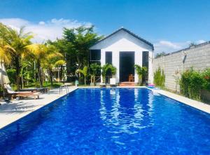 a swimming pool in front of a house at Nos Vetra Resort in Phú Quốc