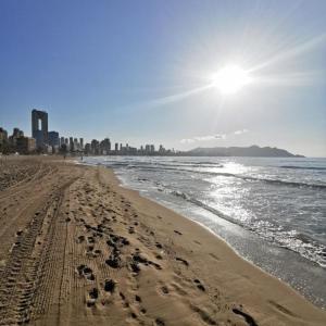 una playa con huellas en la arena y el océano en Apartamento ALMA con terreno privado y parking compartido - a 800m de Playa Poniente, en Benidorm