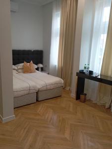 a bedroom with a bed and a wooden floor at La Maison des Fleurs FREE PARKING in Pazardzhik +49 photos