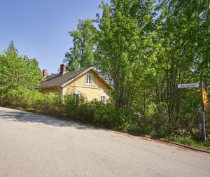 une maison sur le côté d'une route avec un panneau indiquant la rue dans l'établissement Naissaaren Villa Valo, à Jyväskylä