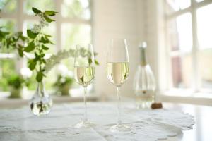 deux verres de vin blanc posés sur une table dans l'établissement Naissaaren Villa Valo, à Jyväskylä