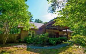una pequeña casa de madera con una valla y árboles en Riversong Retreat, en Pittman Center