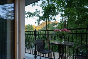 a table and chairs with a vase of flowers on a balcony at Pienińska Róża in Szczawnica +48 photos