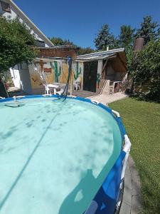 a large swimming pool in the yard of a house at Pelso Holiday Apartments Jasmin in Siófok
