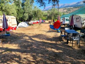 a group of tents and tables and chairs in a field at Aquariumi Jale Camping in Jal