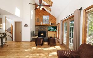 a living room with a ceiling fan and a fireplace at Coppertop View in Gatlinburg