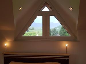 a bedroom with a large window in the attic at Villa BS Sarajevo in Sarajevo
