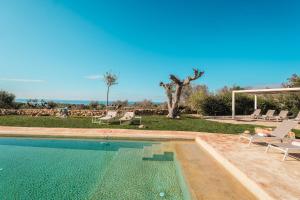 een zwembad met ligstoelen en een zwembad bij KYVOS 10, Emma Villas in Marina di Leuca