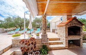 une terrasse avec une cheminée en pierre et des chaises dans l'établissement Villa Jadranka by Villas Guide, à Otočić Ošjak