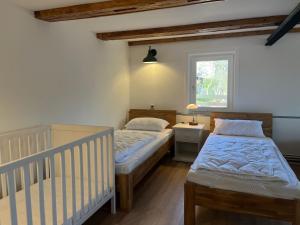 two twin beds in a room with a crib at Ferienhaus Wäschegrund in Sankt Andreasberg