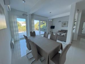 a dining room and living room with a table and chairs at Villa Diel 300m vom Strand in Utjeha