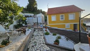 a small yellow house with a garden in front of it at Casa con vistas en Bueu in Bueu +8 photos
