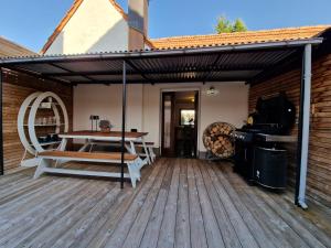a wooden deck with a table and a grill at Ferienhaus Anna mit Kamin, Terrasse, Hof & Garage in Haßloch