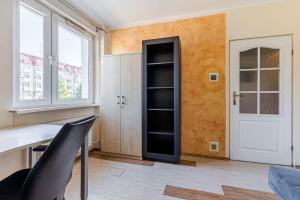 Zimmer mit einem Schreibtisch und einem Fenster in der Unterkunft Laguna Apartment - 1 km to Baltic Sea & 15 Minutes to Gdańsk Old Town in Danzig