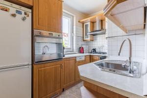 eine Küche mit Spüle und Kühlschrank in der Unterkunft Laguna Apartment - 1 km to Baltic Sea & 15 Minutes to Gdańsk Old Town in Danzig