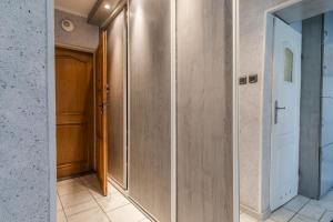 ein Flur mit einer Metalltür und einer Tür in der Unterkunft Laguna Apartment - 1 km to Baltic Sea & 15 Minutes to Gdańsk Old Town in Danzig