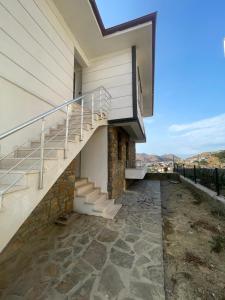 a house with stairs on the side of it at Duplex house with panoramic view in Gökçeada