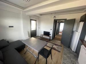 a living room with a table and a couch at Duplex house with panoramic view in Gökçeada