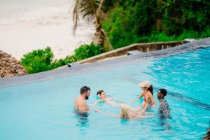 a group of people in a swimming pool at Pearl Beach by Sansi in Michamvi