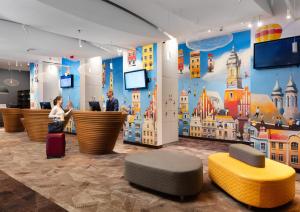 a lobby with people standing at a counter with luggage at Ibis Poznan Centrum in Poznań