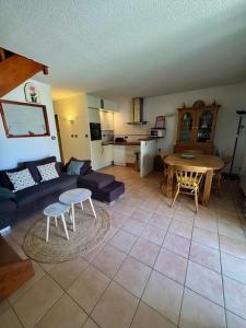 a living room with a couch and a table at Appartement - 4 chambres - piscine collective- place de parking privée (garage) in Saintes-Maries-de-la-Mer