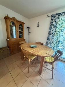 a dining room with a wooden table and chairs at Appartement - 4 chambres - piscine collective- place de parking privée (garage) in Saintes-Maries-de-la-Mer +6 photos