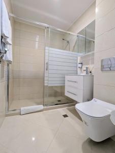 a bathroom with a shower and a toilet and a sink at Burgas Beach Resort 2 Apartments in Burgas City