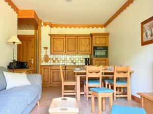 a living room with a table and a kitchen at Mouflon, terrasse confort piscine, Spa in Champagny-en-Vanoise