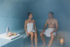 un homme et une femme assis dans une baignoire dans l'établissement Mouflon, 4/6 personnes piscine, Spa, à Champagny-en-Vanoise