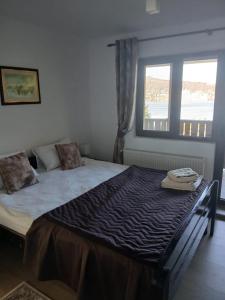 a bedroom with a large bed with a window at Pensiune Agroturistica Oglinda Lacului in Colibiţa
